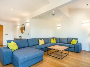 a blue couch in a living room with yellow pillows at Wrens Lake House in South Cerney