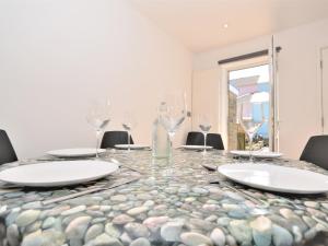 a dining room table with glasses and chairs at Pebble Cottage in Ventnor +13 photos