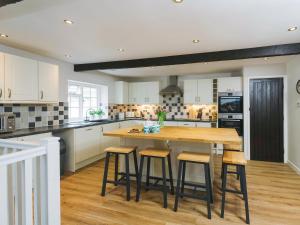 a kitchen with a wooden table and stools at Number Six - Ukc4968 in Tawstock +21 photos
