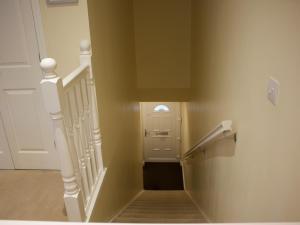 a hallway with a stairway leading to a door at Pine View in Invergarry
