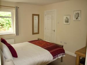 a bedroom with a bed and a window and a mirror at Pine View in Invergarry +3 photos
