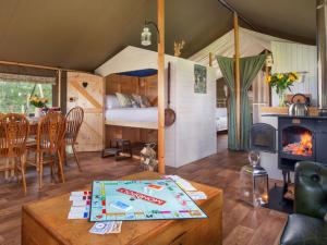 a living room with a bed and a fireplace at 2 Lower Keat Glamping - Ukc4744 in Chardstock