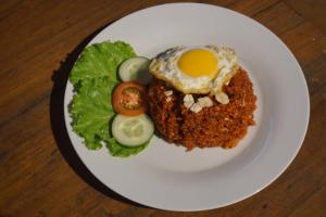 a plate of food with an egg and lettuce at The Umbu Stay Banyuwangi in Banyuwangi +17 photos