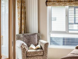 a chair with a book on it next to a window at Rivendale 52 in St. Andrews