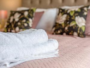 a pair of white towels sitting on a bed at Rivendale 52 in St. Andrews +2 photos