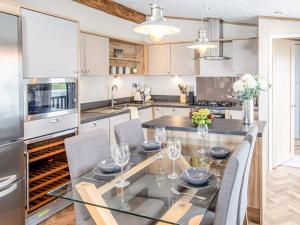 a kitchen with a glass table and chairs at Rivendale 52 in St. Andrews