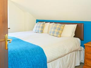 ein Schlafzimmer mit einem Bett mit blauem Kopfteil in der Unterkunft Walnut Walk in Uckfield