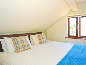 ein Schlafzimmer mit einem Bett mit weißen Laken und Kissen in der Unterkunft Walnut Walk in Uckfield