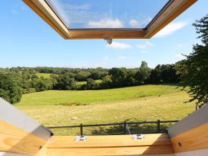 a large window in a house with a view of a field at Holly Cottage in Uckfield