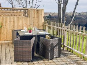 a patio with a table and chairs on a wooden deck at Beech Cottage in Uckfield