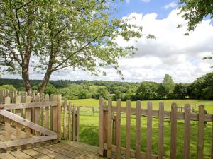 a wooden fence with a view of a field at Beech Cottage in Uckfield