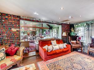 a living room with an orange couch and chairs at Croxton Lodge & Curlews Nest in Croxton Kerrial