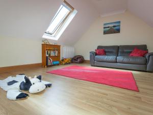 a living room with a cow laying on the floor at Rose Cottage - Ukc6257 in Linlithgow