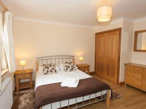 a bedroom with a bed with two night stands and two lamps at Rose Cottage - Ukc6257 in Linlithgow
