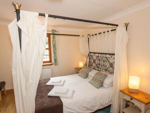 a bedroom with a bed with a canopy at Rose Cottage - Ukc6257 in Linlithgow