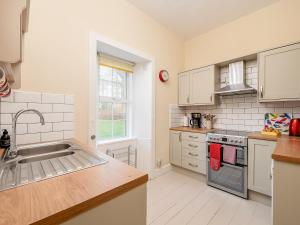 a kitchen with a sink and a stove top oven at The Lodge in Duffus
