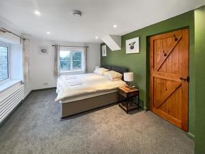 a bedroom with a large bed with a wooden door at Nutley Farmhouse in Uckfield
