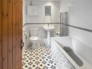 a bathroom with a tub and a toilet and a sink at Nutley Farmhouse in Uckfield +4 photos