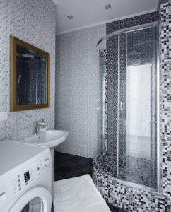 La salle de bains est pourvue d'une douche, d'un lavabo et d'un lave-linge. dans l'établissement City Center Apartment, à Odessa