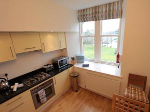 a kitchen with a stove top oven next to a window at Monastery 13 - Abbots Rest - Ukc4886 in Fort Augustus