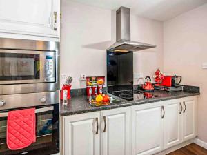 a kitchen with a stove top oven next to a microwave at Mountain View-Ukc5060 in Aviemore