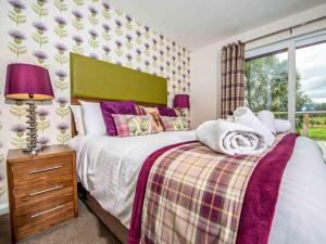 a bedroom with a large bed and a window at Mountain View-Ukc5060 in Aviemore +10 photos