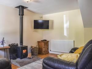 a living room with a couch and a wood stove at Acorn Cottage in Ashover