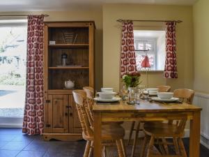 a dining room with a wooden table and chairs at Acorn Cottage in Ashover