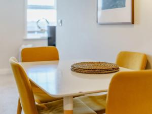a dining room table with yellow chairs and a white table at 4 Eastgate - Uk34281 in Andover