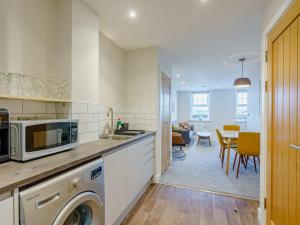 a kitchen with a washer and a dining room at 4 Eastgate - Uk34281 in Andover +14 photos