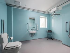 a blue bathroom with a toilet and a sink at Durham Lodge - Ukc5799 in Lundin Links +2 photos