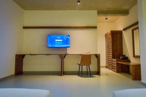 a room with a desk with a tv on the wall at Mistara Ella in Ella