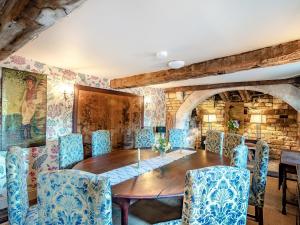 a dining room with a wooden table and blue chairs at Croxton Park House in Croxton Kerrial