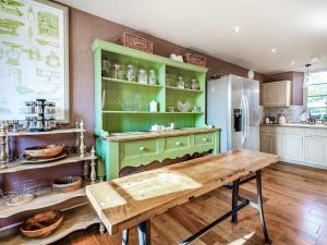 a kitchen with a green cabinet and a wooden table at Croxton Park House in Croxton Kerrial