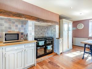 a kitchen with a stove and a microwave at Croxton Park House in Croxton Kerrial