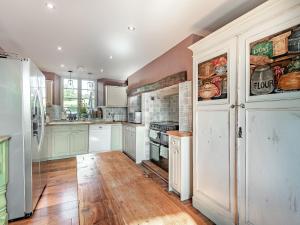 a large kitchen with wooden floors and white appliances at Croxton Park House in Croxton Kerrial +25 photos