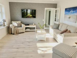 a living room with a couch and a table at Hof Steinhütten Boutique Apartments in Westerhever