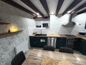 a kitchen with green cabinets and a wooden table at Linstant tranquille in Romorantin