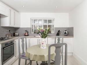 a kitchen with a table and chairs and a vase with flowers at Firlands Lodge - Ukc6205 in Nairn