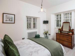 a bedroom with a bed and a dresser and a mirror at Firlands Lodge - Ukc6205 in Nairn +2 photos