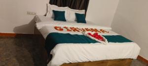 a bed with white sheets and red flowers on it at Girvana Resorts in Sāsan Gīr