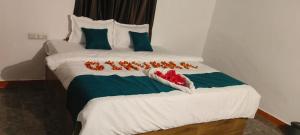 a bed with white sheets and red flowers on it at Girvana Resorts in Sāsan Gīr +7 photos