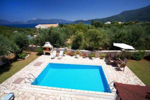 a swimming pool in a yard with chairs at Villa Marina Epavlis by Villa Plus in Karavomylos