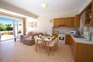 a kitchen and living room with a table and chairs at Villa Marina Epavlis by Villa Plus in Karavomylos