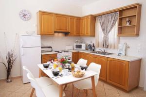 a kitchen with a white table and white appliances at Villa Marina Epavlis by Villa Plus in Karavomylos +10 photos
