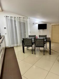 a dining room with a table and chairs and a television at Casa vacanza Helios in Leonforte