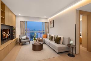 a living room with a couch and a tv at Ascott Guangzhou in Guangzhou