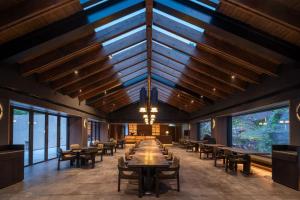 a dining room with tables and chairs and windows at ZOLAND Resort Hotel ·Emei Mountain in Emeishan City