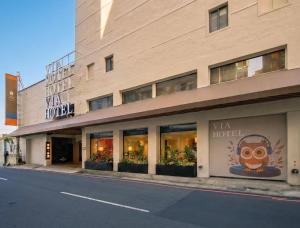 a building with a nha hotel on the side of the street at 丰居中壢 Via Hotel Zhongli in Zhongli