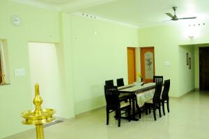 a dining room with a table and chairs at SHANKARAM Homestay in Kodanad